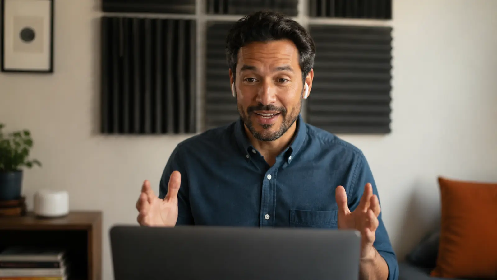 Person on a video call at a desk in a treated home office with foam panels visible on the wall behind them